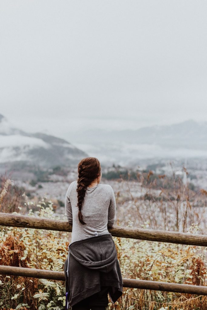 a woman in mountains is looking at the view