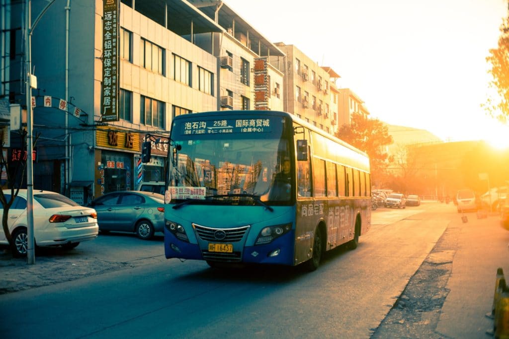 a bus on a road with a sunset 