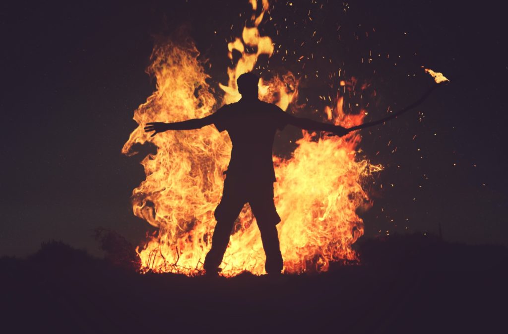a man in front a big fire 