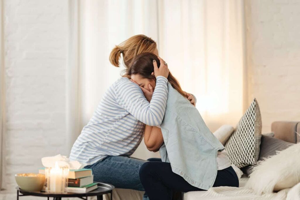 woman comforting another woman