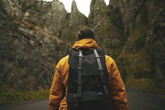 a hiker with a backpack walking on a mountain road
