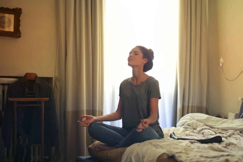 a woman meditating in her room