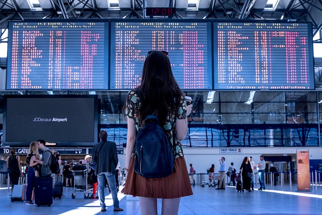 female traveler checking flight schedule at airport terminal