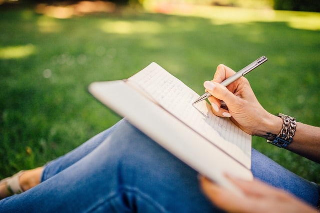woman focused on writing in a notebook