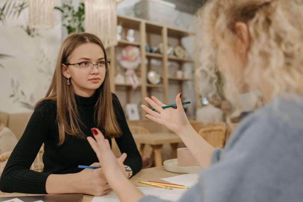 woman in black listens to her friend while deciding