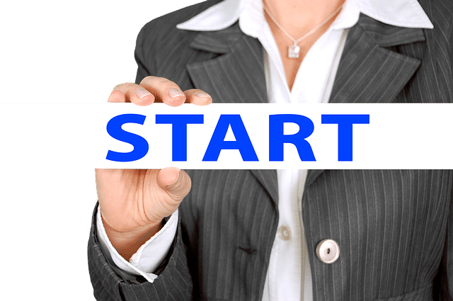 woman in business suit holds sign saying start