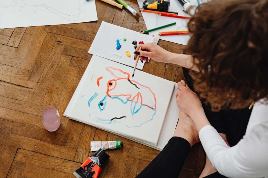 woman painting while sitting on the floor