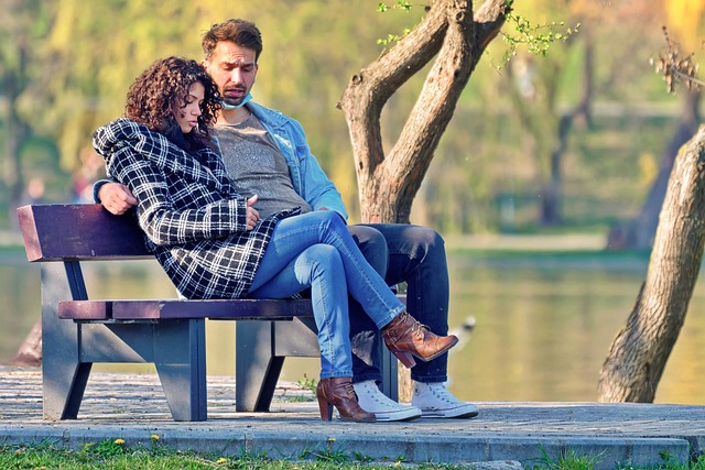 a man and woman unwind on a bench by a tranquil lake