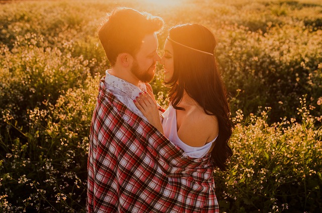 romantic couple enjoying sunset in field