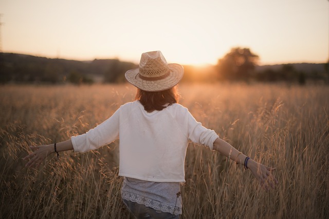 Woman in hat, arms outstretched, symbolizing freedom