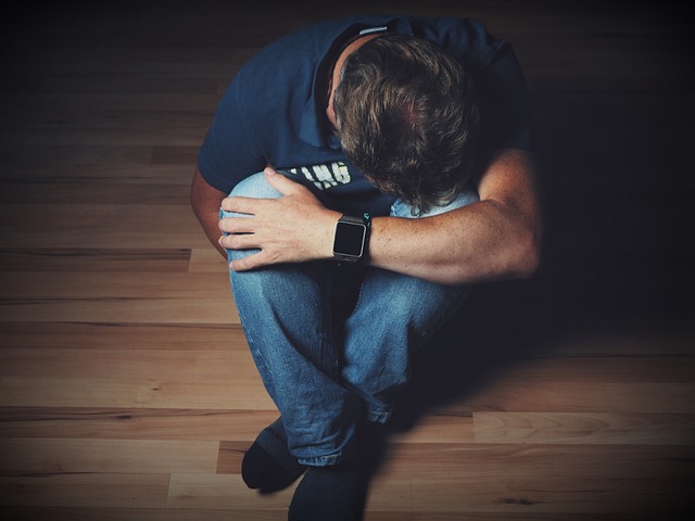 emotional man sitting on the floor with head in hands