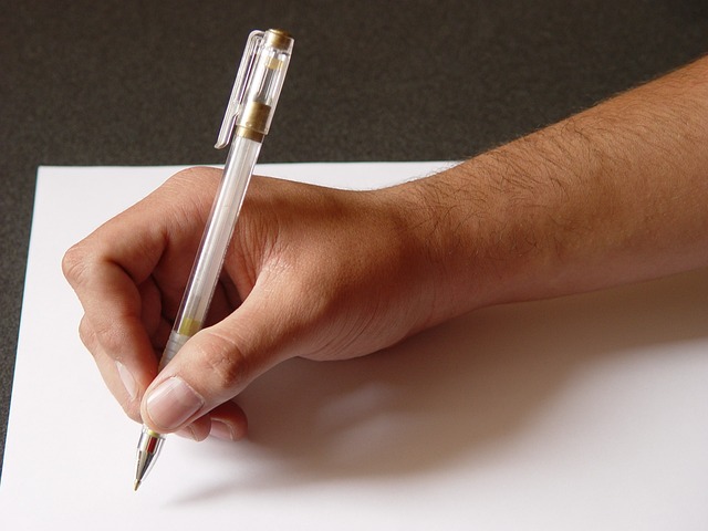 a person writing with a pen