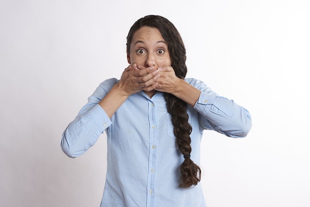 a woman covering her mouth, unable to speak