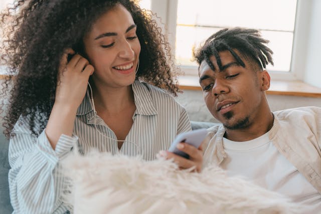 a woman showing a man the music she listens to