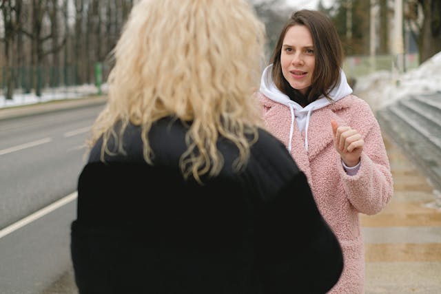 a woman talking with a friend on the street, building a connection
