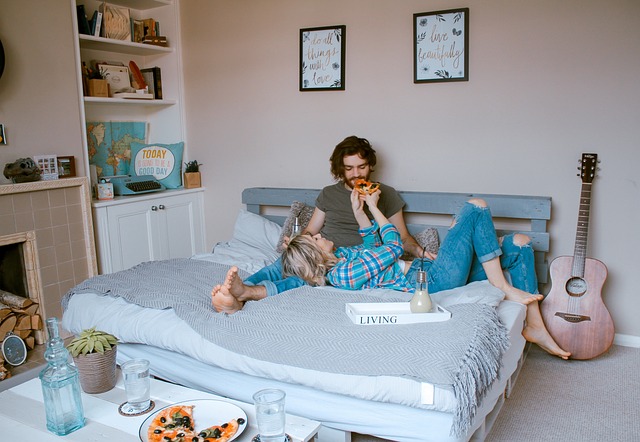 couple on bed enjoying pizza together