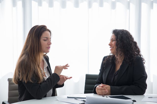 women in corporate attire having a discussion