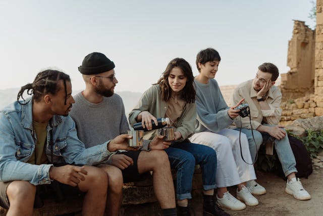 friends sitting on a concrete bench, enjoying coffee