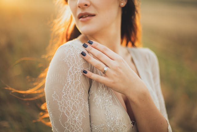 woman in gray lace top standing at sunset