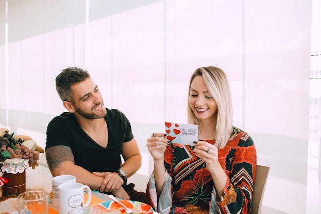 woman joyfully surprised by man's greeting card