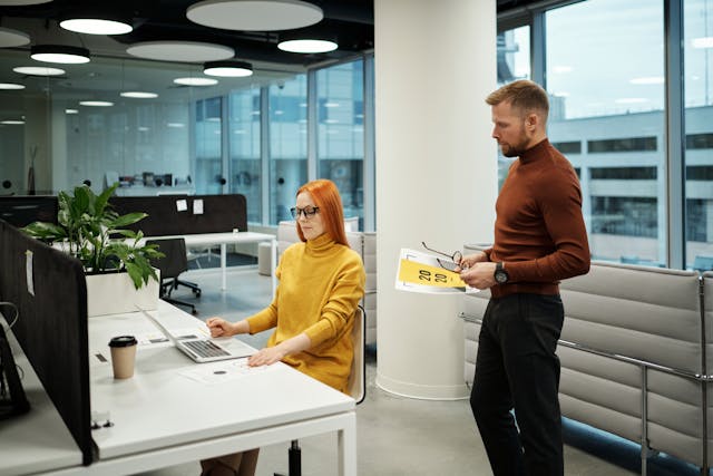 a man and a woman working together in the office