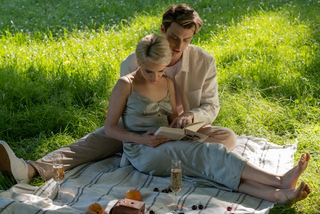 a couple on a picnic is discussing something from a book