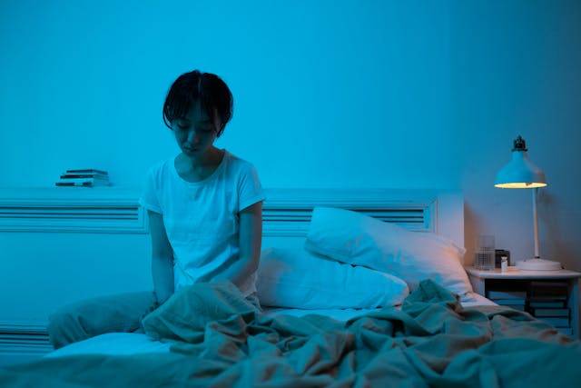 a girl just woke up, sitting alone on the bed, thinking about her dream