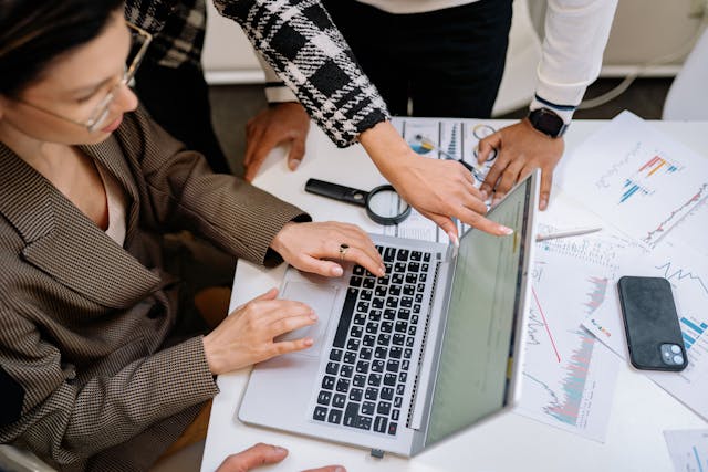 a woman pointing at a laptop to defend her idea