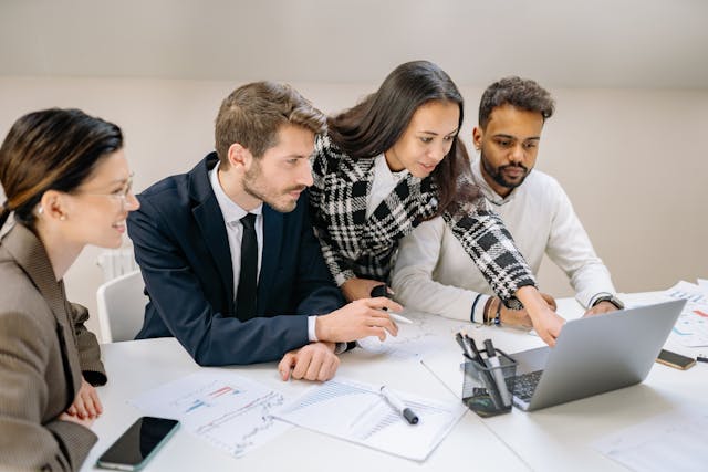a woman pointing at the laptop screen during a brainstorming session