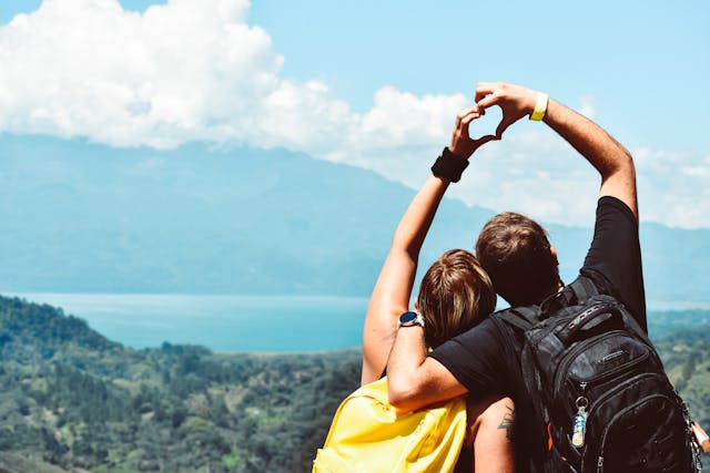 adventurous couple forming a heart with their hands